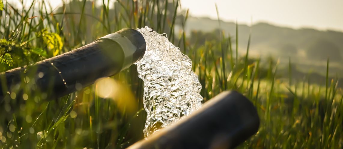 Foto: shutterstock Wasser aus einem Brunnen füllt einen Teich zur Bewässerung