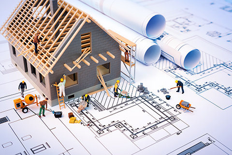  Hausbau auf Bauplänen mit Arbeiter - Bauprojekt
