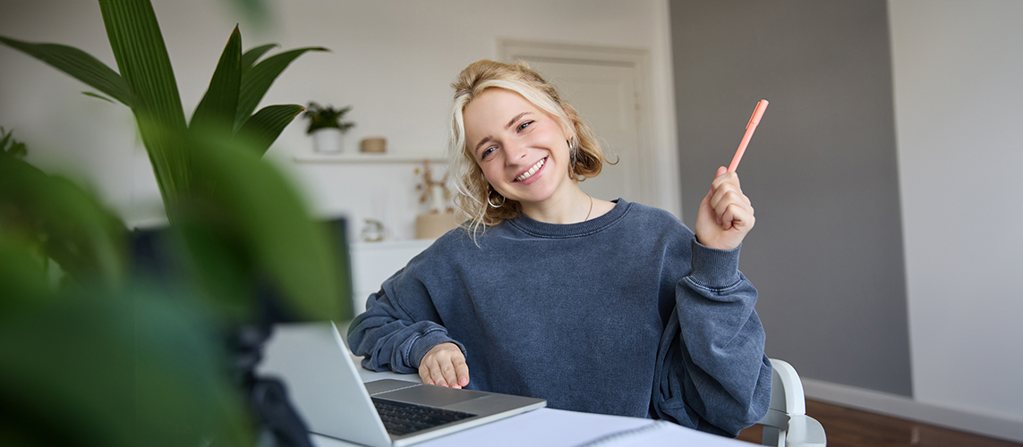 Foto: benzoix/Freepik Porträt einer jungen lächelnden Frau, einer Studentin, die online per Videochat mit dem Lehrer spricht, einen Kurs absolviert, einen Fernkurs im Internet besucht und sich Notizen macht